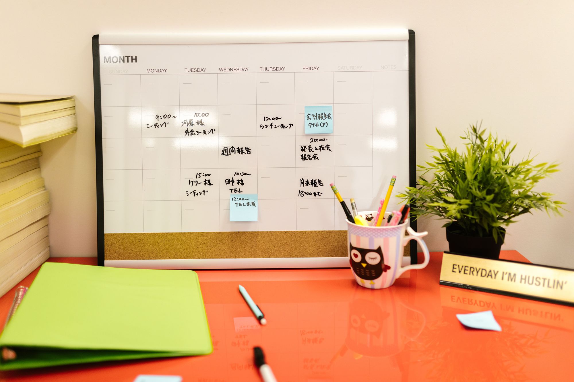 Wall calendar and desk setup used as a shared bill calendar and reminder board
